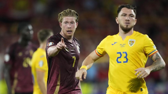 Belgiums Kevin De Bruyne gestures besides Romanias Deian Sorescu during a Group E match between Belgium and Romania at the Euro 2024 soccer tournament in Cologne, Germany, Saturday, June 22, 2024. (AP Photo/Martin Meissner)