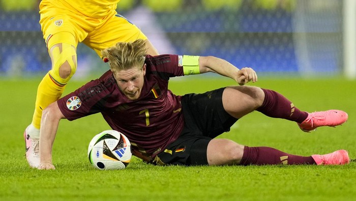 Belgiums Kevin De Bruyne is challenged by Romanias Razvan Marin during a Group E match between Belgium and Romania at the Euro 2024 soccer tournament in Cologne, Germany, Saturday, June 22, 2024. (AP Photo/Andreea Alexandru)