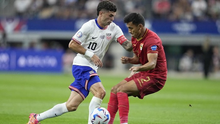 Christian Pulisic of the United States, left, and Bolivias Jesus Sagredo battle for the ball during a Copa America Group C soccer match in Arlington, Texas, Sunday, June 23, 2024. (AP Photo/Tony Gutierrez)
