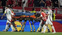 Para pemain membantu petugas medis mendorong tandu keluar lapangan. Permainan akhirnya dilanjutkan dan Hungaria menang 1-0, yang kemudian didedikasikan rekan-rekannya untuk Barnabas Varga.  Kemenangan membuat Hungaria menjaga kans lolos ke 16 besar Euro 2024. (Foto: Matthias Schrader/AP)