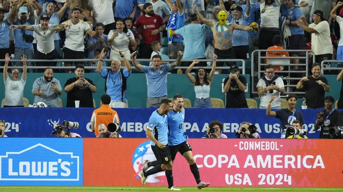 Uruguays Matias Vina, right, celebrates with teammate Sebastian Caceres after scoring his sides third goal against Panama during a Copa America Group C soccer match in Miami Gardens, Fla, Sunday, June 23, 2024. (AP Photo/Rebecca Blackwell)