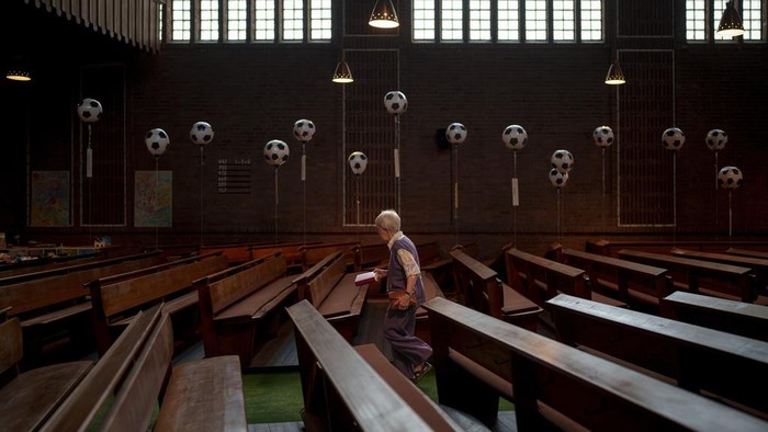Meriahkan Euro 2024, Gereja di Jerman Dihias Bak Lapangan Bola A woman walks an aisle decorated with inflatable soccer themed balloons in the Emmaus Evangelical Church, in Gelsenkirchen, Germany, Sunday, June 23, 2024. (AP Photo/Andreea Alexandru)