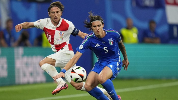 Croatias Luka Modric, left, and Italys Riccardo Calafiori challenge for the ball during a Group B match between Croatia and Italy at the Euro 2024 soccer tournament in Leipzig, Germany, Monday, June 24, 2024. (AP Photo/Petr David Josek)