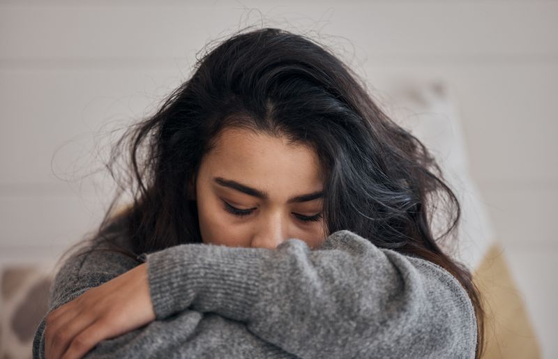 Woman, tertekan and depression in lonely mental health problems, issues or anxiety at home. Sad female face suffering from loneliness, withdrawal or abuse with depressed emotion alone in the bedroom