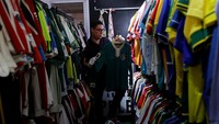 Cassio Brandao dari Brasil berjalan melewati ruangan yang dipenuhi rak pakaian sepakbola di Sao Paulo, Brasil, Senin (24/6/2024).