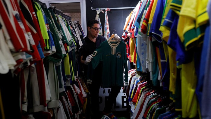 Gokil! Pria Brasil Pecahkan Rekor Koleksi Kaos Bola Terbanyak di Dunia Cassio Brandao, 41, holds a shirt worn by Pele in a room filled with clothes racks that in April 2024 made him become a Guinness World Records title holder as the owner of the world's largest collection of soccer shirts, in Sao Paulo, Brazil June 24, 2024. REUTERS/Amanda Perobelli