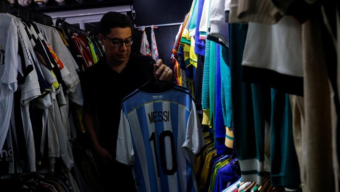 Cassio Brandao, 41, holds a shirt worn by Pele in a room filled with clothes racks that in April 2024 made him become a Guinness World Records title holder as the owner of the world's largest collection of soccer shirts, in Sao Paulo, Brazil June 24, 2024. REUTERS/Amanda Perobelli