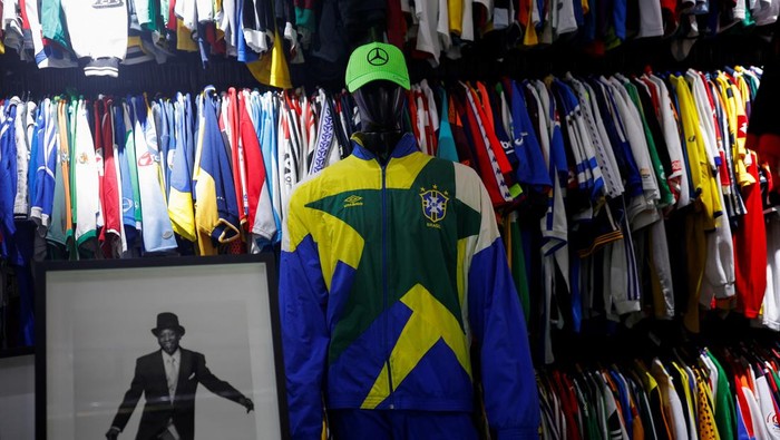 Cassio Brandao, 41, holds a shirt worn by Pele in a room filled with clothes racks that in April 2024 made him become a Guinness World Records title holder as the owner of the world's largest collection of soccer shirts, in Sao Paulo, Brazil June 24, 2024. REUTERS/Amanda Perobelli