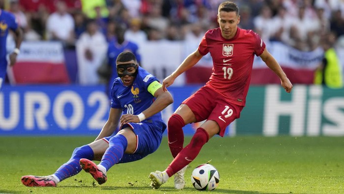 Kylian Mbappe of France, right, is defended by Polands Przemyslaw Frankowski during a Group D match between France and Poland at the Euro 2024 soccer tournament in Dortmund, Germany, Tuesday, June 25, 2024. (AP Photo/Hassan Ammar)