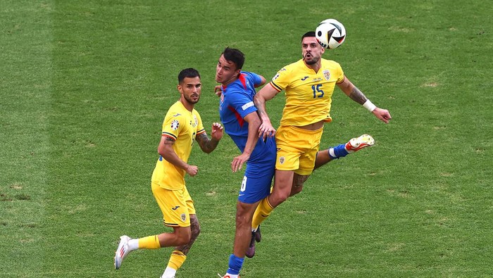 FRANKFURT AM MAIN, GERMANY - JUNE 26: Andrei Burca of Romania jumps for the ball with David Strelec of Slovakia during the UEFA EURO 2024 group stage match between Slovakia and Romania at Frankfurt Arena on June 26, 2024 in Frankfurt am Main, Germany. (Photo by Alex Grimm/Getty Images)