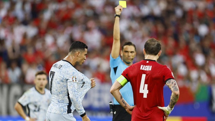 Soccer Football - Euro 2024 - Group F - Georgia v Portugal - Arena AufSchalke, Gelsenkirchen, Germany - June 26, 2024  Portugals Cristiano Ronaldo is shown a yellow card by referee Sandro Scharer REUTERS/Leon Kuegeler