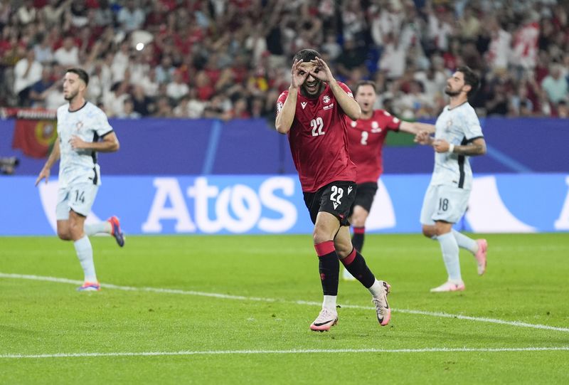Georgia's Georges Mikautadze celebrates after scoring on a penalty kick during a Group F match between Georgia and Portugal at the Euro 2024 soccer tournament in Gelsenkirchen, Germany, Wednesday, June 26, 2024. (AP Photo/Martin Meissner)