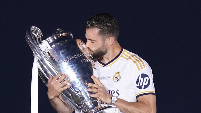 Soccer Football - Real Madrid celebrate winning the Champions League - Cibeles Fountain, Madrid, Spain - June 2, 2024 Real Madrids Nacho celebrates with the trophy after placing the traditional scarf at the Fuente de las Cibeles after winning the Champions League. REUTERS/Ana Beltran