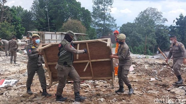 Satpol PP bersihkan puing sisa pembongkaran di Puncak Bogor. (Sholihin/detikcom)