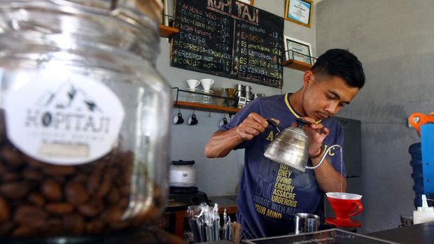 Barista menyeduh kopi pesanan pelanggan di Kafe Lereng Bromo di desa Taji, Jabung, Malang.