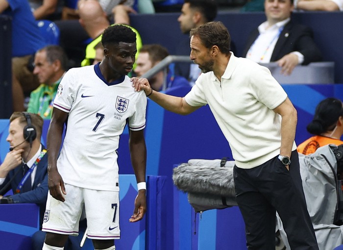 Soccer Football - Euro 2024 - Round of 16 - England v Slovakia - Arena AufSchalke, Gelsenkirchen, Germany - June 30, 2024 England manager Gareth Southgate gives instructions to Bukayo Saka REUTERS/John Sibley