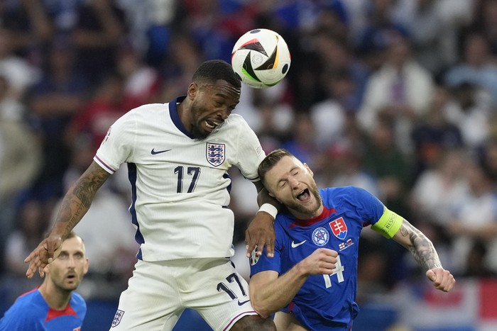 Englands Ivan Toney, left, heads the ball past Slovakias Milan Skriniar during a round of sixteen match between England and Slovakia at the Euro 2024 soccer tournament in Gelsenkirchen, Germany, Sunday, June 30, 2024. (AP Photo/Antonio Calanni)