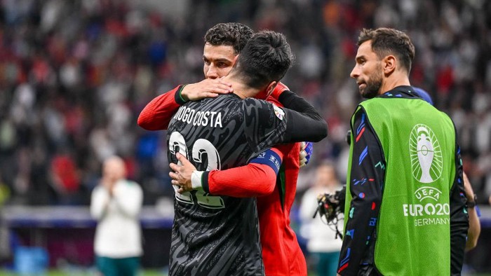 FRANKFURT AM MAIN, GERMANY - JULY 1: goalkeeper Diogo Costa of Portugal and Cristiano Ronaldo of Portugal celebrate after winning the UEFA EURO 2024 round of 16 match between Portugal and Slovenia at Frankfurt Arena on July 1, 2024 in Frankfurt am Main, Germany. (Photo by Harry Langer/DeFodi Images/DeFodi via Getty Images)