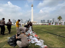 Polisi Bersih-bersih Kawasan Monas Usai Pesta Rakyat Hari Bhayangkara