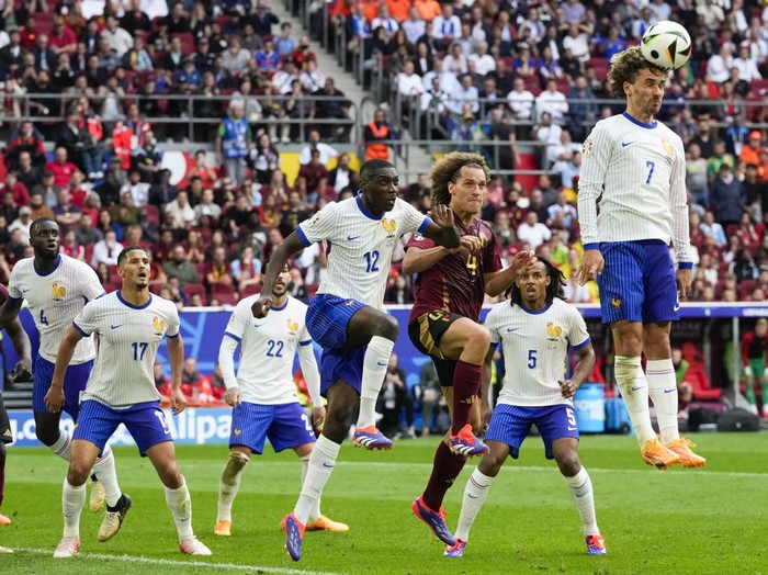 Antoine Griezmann of France, right, heads the ball during a round of sixteen match between France and Belgium at the Euro 2024 soccer tournament in Duesseldorf, Germany, Monday, July 1, 2024. (AP Photo/Frank Augstein)