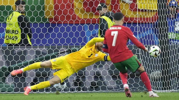 Slovenias goalkeeper Jan Oblak blocks a penalty kick by Portugals Cristiano Ronaldo (7) during a round of sixteen match at the Euro 2024 soccer tournament in Frankfurt, Germany, Monday, July 1, 2024. (AP Photo/Ebrahim Noroozi)