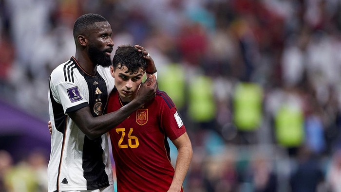 AL KHOR, QATAR - NOVEMBER 27:  Antonio Rudiger of Germany hugs Pedri of Spain at the end of the FIFA World Cup Qatar 2022 Group E match between Spain and Germany at Al Bayt Stadium on November 27, 2022 in Al Khor, Qatar. (Photo by Juan Luis Diaz/Quality Sport Images/Getty Images)
