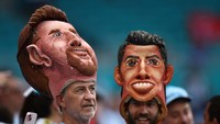 Ada juga yang memakai topi bergambar Messi dan Ronaldo. Keduanya sama-sama dilabeli dengan GOAT oleh para penggemarnya.  