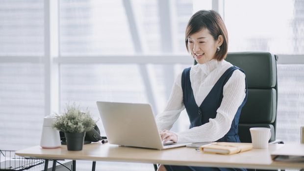 asian chinese beautiful female manager working using her laptop typing in the office