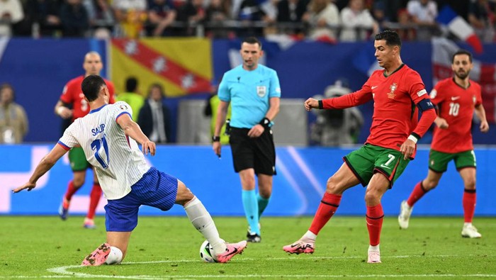 Soccer Football - Euro 2024 - Quarter Final - Portugal v France - Hamburg Volksparkstadion, Hamburg, Germany - July 5, 2024 Frances William Saliba in action with Portugals Cristiano Ronaldo REUTERS/Carmen Jaspersen