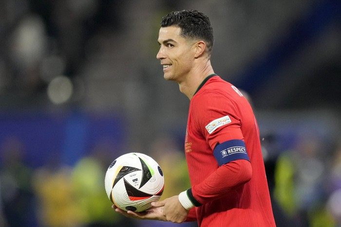 Cristiano Ronaldo Portugal's Cristiano Ronaldo holds the ball during a quarter final match between Portugal and France at the Euro 2024 soccer tournament in Hamburg, Germany, Friday, July 5, 2024. (AP Photo/Martin Meissner)