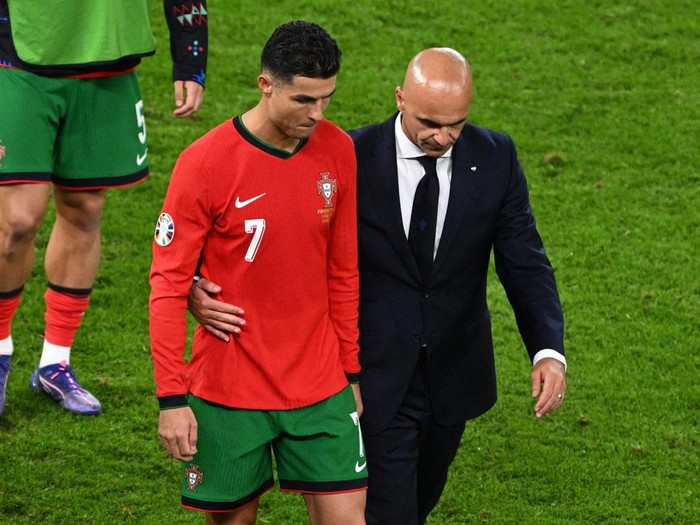 Soccer Football - Euro 2024 - Quarter Final - Portugal v France - Hamburg Volksparkstadion, Hamburg, Germany - July 5, 2024 Portugal coach Roberto Martinez consoles Cristiano Ronaldo after losing the penalty shootout REUTERS/Annegret Hilse TPX IMAGES OF THE DAY