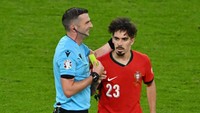Kartu itu sungguh-sungguh dikasihkan oleh si pemain Portugal kepada Oliver. Sebelumnya, si pengadil lapangan tak sadar kartu kuningnya terjatuh dari kantong. Foto: Getty Images/Dan Mullan
