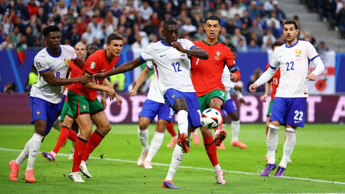 Soccer Football - Euro 2024 - Quarter Final - Portugal v France - Hamburg Volksparkstadion, Hamburg, Germany - July 5, 2024 Frances Randal Kolo Muani in action with Portugals Cristiano Ronaldo REUTERS/Lisi Niesner