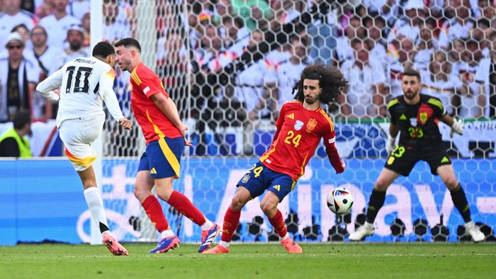 05 July 2024, Baden-Württemberg, Stuttgart: Soccer, UEFA Euro 2024, European Championship, Spain - Germany, final round, quarter-final, Stuttgart Arena, Germanys Jamal Musiala (l-r) in action against Spains Aymeric Laporte, Marc Cucurella and goalkeeper Unai Simon. Photo: Tom Weller/dpa (Photo by Tom Weller/picture alliance via Getty Images)