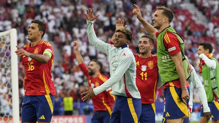 Spains Rodri, left, and Lamine Yamal, center, celebrates with teammates after a quarterfinal match between Germany and Spain at the Euro 2024 soccer tournament in Stuttgart, Germany, Friday, July 5, 2024. (AP Photo/Antonio Calanni)