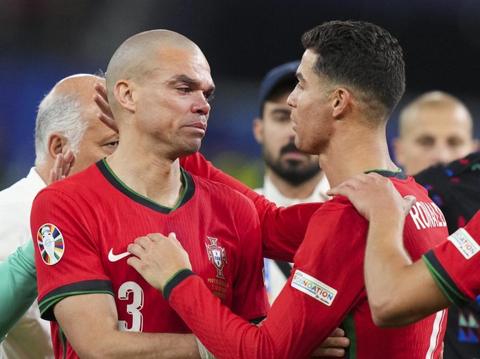 HAMBURG, GERMANY - JULY 5: Portugal's forward Cristiano Ronaldo (R) comforts Portugal's defender Pepe (L) following Theo Hernandez's penalty gives victory to France in the UEFA Euro 2024 quarter-final football match between Portugal and France at the Volksparkstadion in Hamburg on July 5, 2024. (Photo by Emin Sansar/Anadolu via Getty Images)