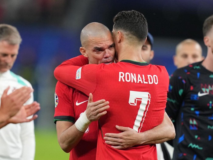 HAMBURG, GERMANY - JULY 5: Portugal's forward Cristiano Ronaldo (R) comforts Portugal's defender Pepe (L) following Theo Hernandez's penalty gives victory to France  in the UEFA Euro 2024 quarter-final football match between Portugal and France at the Volksparkstadion in Hamburg on July 5, 2024. (Photo by Emin Sansar/Anadolu via Getty Images)