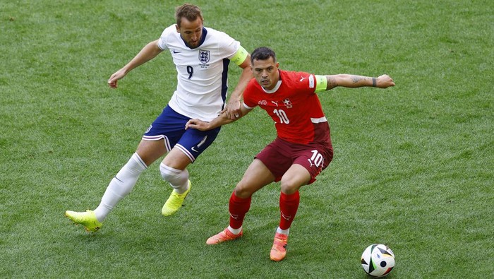 Soccer Football - Euro 2024 - Quarter Final - England v Switzerland - Dusseldorf Arena, Dusseldorf, Germany - July 6, 2024 Englands Harry Kane in action with Switzerlands Granit Xhaka REUTERS/Piroschka Van De Wouw