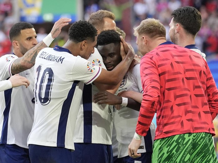 England's Bukayo Saka, center, is congratulated after scoring his side's first goal during a quarterfinal match between England and Switzerland at the Euro 2024 soccer tournament in Duesseldorf, Germany, Saturday, July 6, 2024. (AP Photo/Martin Meissner)