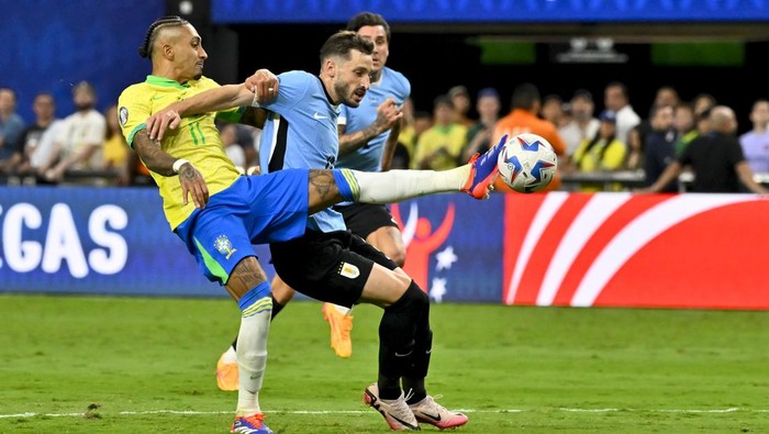 Brazils Raphinha (11) and Uruguays Matias Vina battle for the ball during a Copa America quarterfinal soccer match in Las Vegas, Saturday, July 6, 2024. (AP Photo/David Becker)