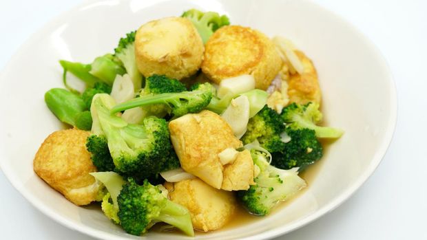 Thai food, Stir-fried broccoli and deep-fried Egg-Tofu with oyster sauce. Healthy food image on white background, view side and above a 45-degree angle.