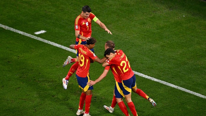MUNICH, GERMANY - JULY 09: Dani Olmo of Spain celebrates with teammates after Jules Kounde of France (not pictured) concedes an own goal, resulting in the second goal for Spain, during the UEFA EURO 2024 Semi-Final match between Spain and France at Munich Football Arena on July 09, 2024 in Munich, Germany. (Photo by Tullio Puglia - UEFA/UEFA via Getty Images)