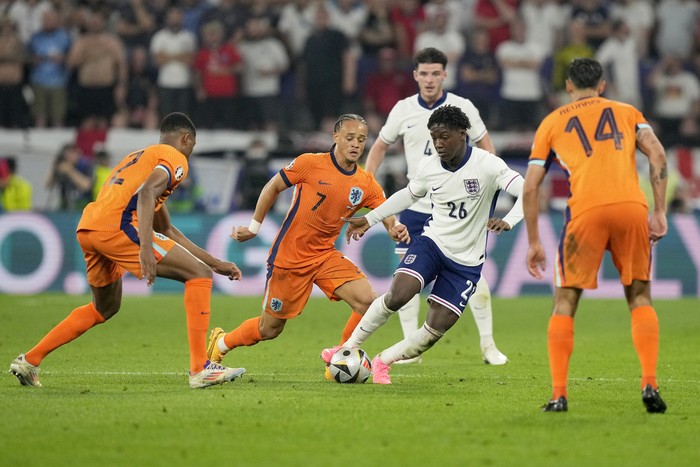 Englands Kobbie Mainoo controls the ball next to Xavi Simons of the Netherlands, 2nd left, during a semifinal match between the Netherlands and England at the Euro 2024 soccer tournament in Dortmund, Germany, Wednesday, July 10, 2024. (AP Photo/Martin Meissner)