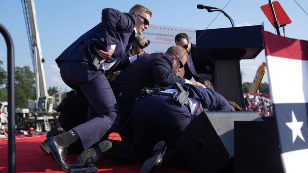 Republican presidential candidate former President Donald Trump is covered by U.S. Secret Service agents at a campaign rally, Saturday, July 13, 2024, in Butler, Pa. (AP Photo/Evan Vucci)