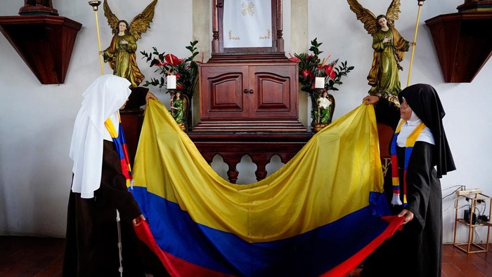 Poor Clare Sisters unfold a flag during a prayer as they support the Colombian national team in the Copa America final against Argentina, at a convent in Montenegro, Colombia  July 13, 2024. REUTERS/Vladimir Encina