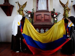 Para suster ini juga membentangkan bendera kolombia di dalam gereja.