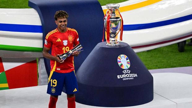 Soccer Football - Euro 2024 - Final - Spain v England - Berlin Olympiastadion, Berlin, Germany - July 14, 2024Spain's Lamine Yamal walks past the trophy after collecting his winners medal REUTERS/Kai Pfaffenbach