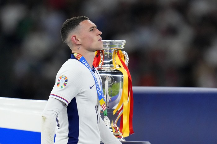 Englands Phil Foden walks past the trophy after the final match between Spain and England at the Euro 2024 soccer tournament in Berlin, Germany, Sunday, July 14, 2024. Spain won 2-1. (AP Photo/Manu Fernandez)
