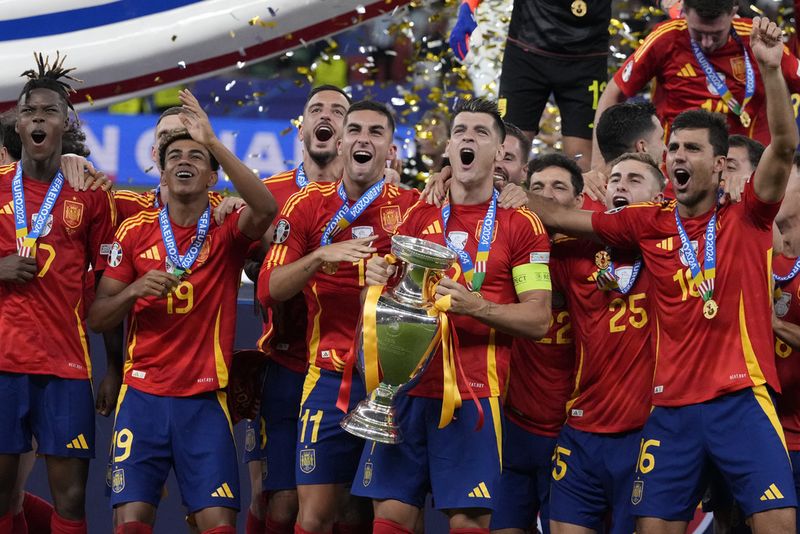 Spain's Alvaro Morata holds the trophy as he celebrates with his teammates after winning the final match between Spain and England at the Euro 2024 soccer tournament in Berlin, Germany, Sunday, July 14, 2024. Spain won 2-1. (AP Photo/Frank Augstein)