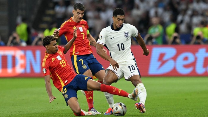14 July 2024, Berlin: Soccer, UEFA Euro 2024, European Championship, Final, Spain - England, Olympiastadion Berlin, Spains Lamine Yamal (l) and Spains Alvaro Morata (M) fight for the ball around Englands Jude Bellingham. Photo: Federico Gambarini/dpa (Photo by Federico Gambarini/picture alliance via Getty Images)
